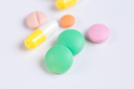 Medicine green and yellow pills or capsules on a white background with copy space.の写真素材