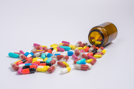 Assorted pharmaceutical medicine pills, tablets in the glass bottle on a white backgroundの写真素材