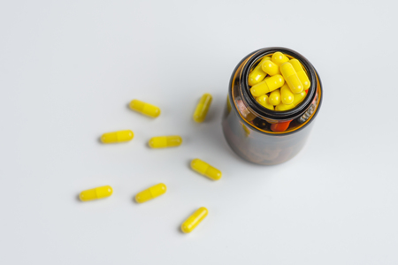 Assorted pharmaceutical medicine pills, tablets in the glass bottle on a white backgroundの写真素材