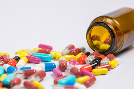 Assorted pharmaceutical medicine pills, tablets in the glass bottle on a white backgroundの写真素材