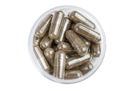 Medicine brown pills in the white bottle on white background. Close-up photography of tablets or pills.の写真素材