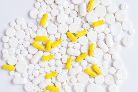 White and yellow pills or tablets  on a white background with copy spaceの写真素材