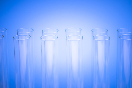 Laboratory test tubes,science background abstract. Glass test tubes in a stand on blue background.の写真素材