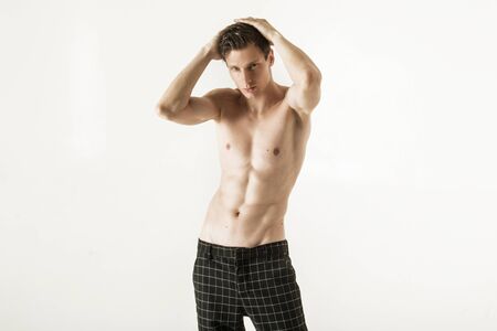Strong stripped muscle male model in trousers on white font backgroundの写真素材