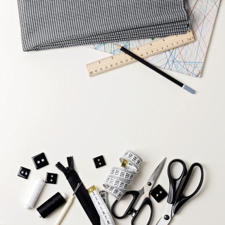 Everything for sewing in black and white. Fabric and thread, zipper and buttons, scissors and...