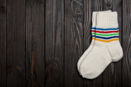 Knit white wool socks on dark wooden background.の写真素材