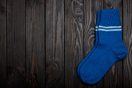 Knit blue wool socks on dark wooden background.の写真素材