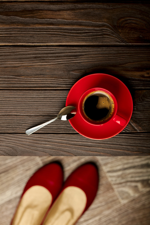 Cup of coffee on a wooden table and womens shoes. Selective focus.の写真素材
