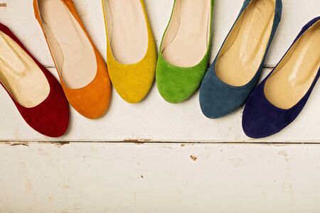 Row of colorful shoes (ballerinas) on a white wooden background. Selective focus.の写真素材