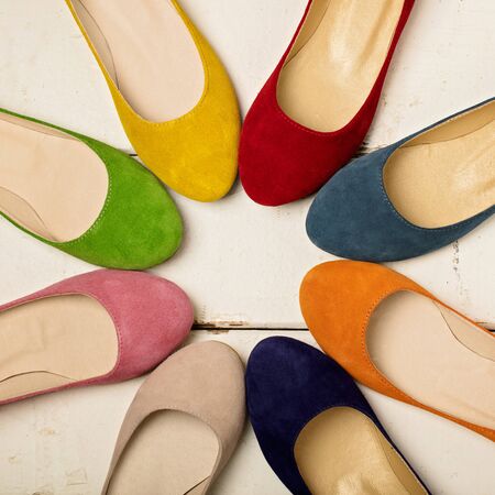 Row of colorful shoes (ballerinas) on a white wooden background. Selective focus.の写真素材
