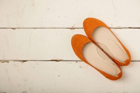 Orange women's shoes (ballerinas) on wooden background. Selective focus.の写真素材