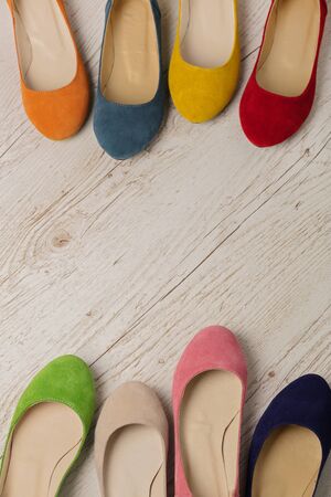 Row of colorful shoes (ballerinas) on a white wooden background. Selective focus.の写真素材