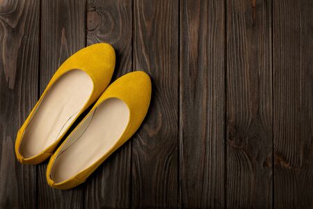 Yellow women's shoes (ballerinas) on wooden background. Selective focus.の写真素材
