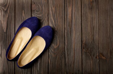 Blue women's shoes (ballerinas) on wooden background. Selective focus.の写真素材