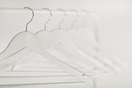 Black-and-white photo with the blur. White Row of hangers on the rack. Selective focus.の写真素材