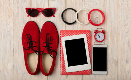 Red women shoes oxfords, bracelets and sunglasses, smartphone and e-book. Selective focus.の写真素材