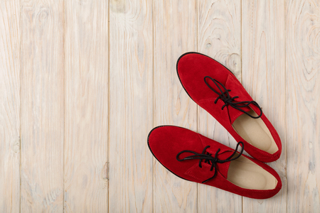 Red women's shoes oxfords on a light wooden background. Selective focus.の写真素材