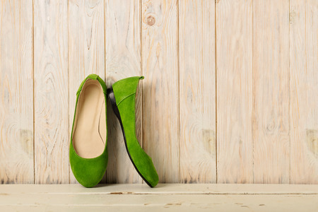 Green women's shoes (ballerinas) on wooden background. Selective focus.の写真素材