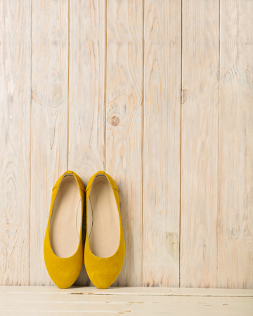 Yellow women's shoes (ballerinas) on wooden background. Selective focus.の写真素材