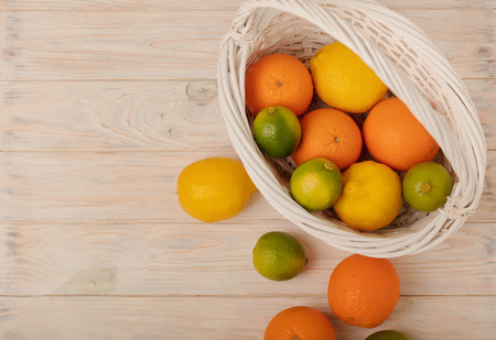 Citrus fruits - lemons, oranges and limes on a light wooden background. Selective focus.の写真素材