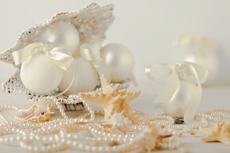 Christmas and New Year. Christmas-tree white toys in a marine style, seashells stones and starfish. Selective focus.の写真素材