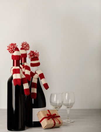 Merry Christmas and a Happy New Year Bottles of wine in a knitted cap of Santa Claus. Selective focus.の写真素材
