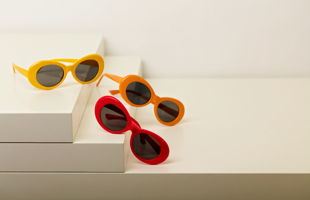 Sunglasses of red, orange and yellow colors on a white background. Selective focus.の写真素材
