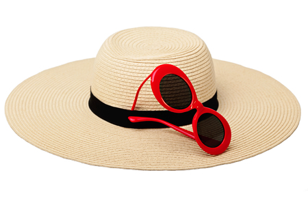 Summer woman's hat and sunglasses of red color on isolated background. Selective focus.の写真素材