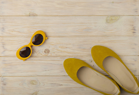 Women's ballet flats and sunglasses are yellow color. Selective focus.の写真素材
