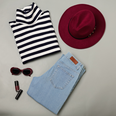 Fashion set of blue jeans, striped sweater, burgundy hat and sunglsses. Flat lay. Top view.の写真素材