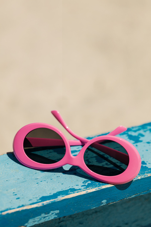 Sunglasses of pink color on the beach. Selective focus.の写真素材