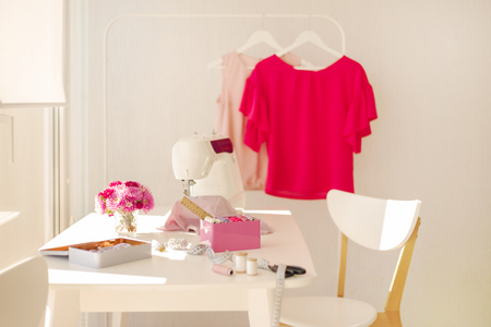 Workplace for sewing and needlework in a bright room with white furniture. Blurring effect and selective focus.の写真素材