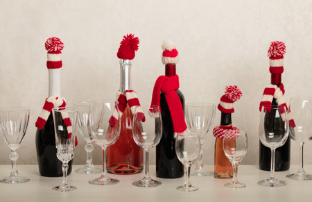 Merry Christmas and Happy New Year! Holiday knitted decor - Santa Claus knitted hats on the bottle with wine. Selective focus.の写真素材