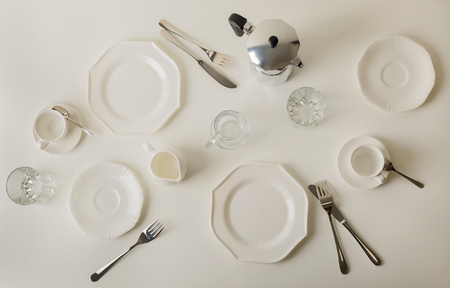Breakfast time. Table setting for brearfast. Crockery, plates, cups and coffee maker. Breakfast on a white table.の写真素材