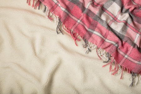 Winter time. A cozy warm pink blanket and a cup of coffee and croissants on the bed. Selective...