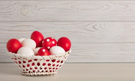 Happy Easter! Painted Easter eggs - red, white and red with white polka dots on a gray wooden background. Selective focus.の写真素材