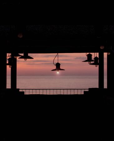 Beautiful sunset (sunrise) on a cafe background with lamps in retro style. Background with copy space.の写真素材