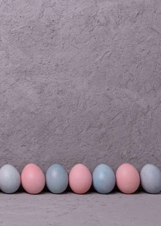 Pattern of chicken painted pink and blue Easter eggs on gray backgroundの写真素材