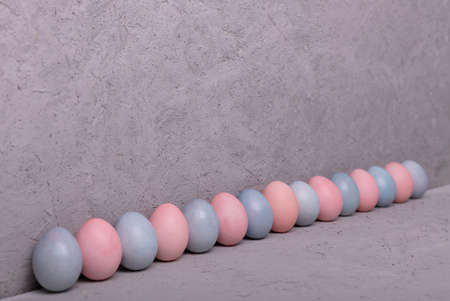 Pattern of chicken painted pink and blue Easter eggs on gray backgroundの写真素材