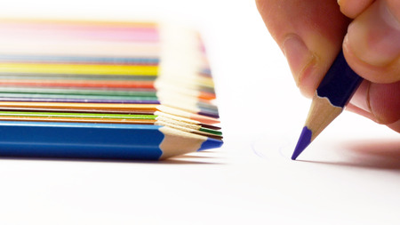 Male hand painting with colored pencils and putting pencilの写真素材