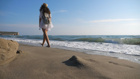 Couple of lovers walking at coast and hugging during resting on resort. Man and woman strolling on beach and enjoying summer vacation together. Honeymoon of young pair. Concept of love or vacationの写真素材