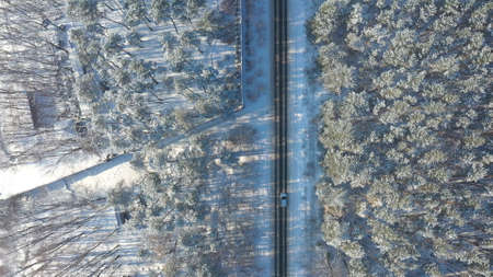 White car riding through snowy rural road. Following to SUV driving at beautiful countryside route...