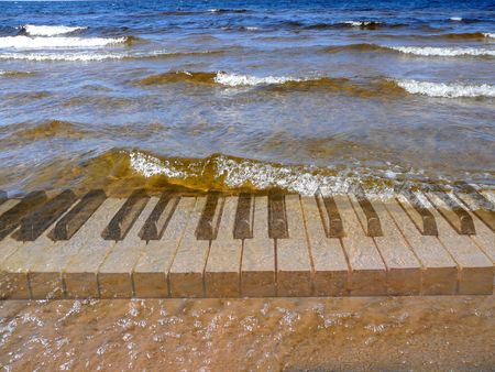 piano keyboard under surf wavesの写真素材
