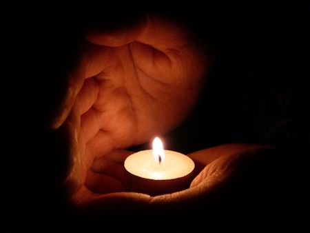 two palms take care of candle fireの写真素材