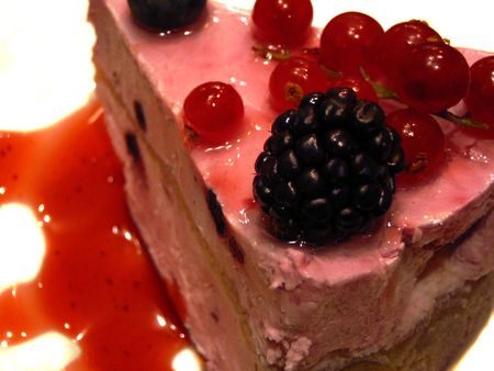 piece of  yogurt cream cake decorated fresh berries on white plateの写真素材