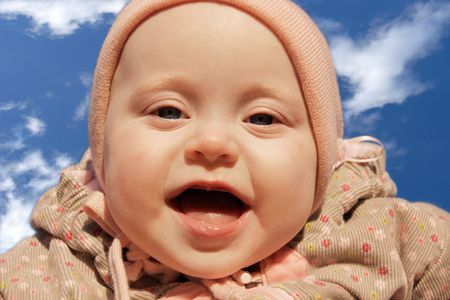 baby girl is delighted with something, looks in camera