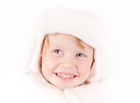little girl in white winter fleece hat with ear flaps & mittens portrait on whiteの写真素材