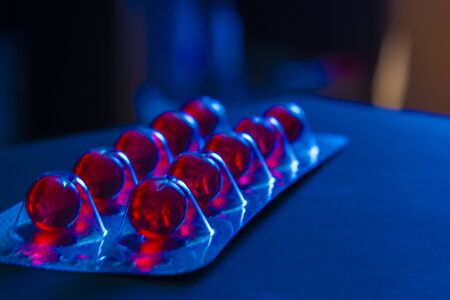 Bright red drugs in round capsules in packing plate