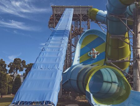 Big high waterslide for extreme descents. People slide along the wall at high speed on a large...