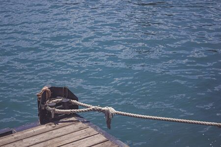 Bollard on the wooden dock and tied a rope sea knotの写真素材